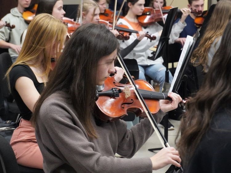 Group of orchestra students playing their violins